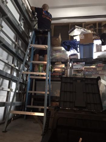Sure Fix Garage Door Repair expert on a ladder 