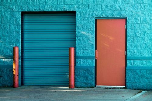 brown-panel-door-near-roll-up-garage door